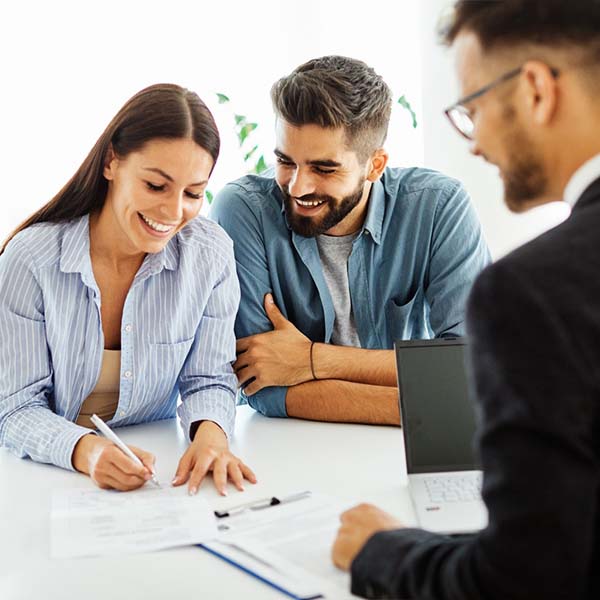 Real,Estate,Agent,With,Couple,Closing,A,Deal,And,Signing